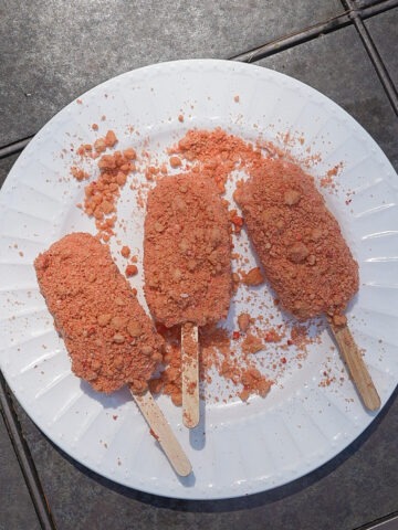 strawberry shortcake ice cream bars coated in the strawberry shortcake mixture