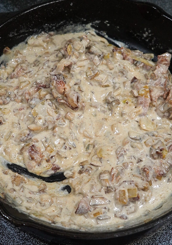 Adding the bacon, mushrooms, onions and heavy cream mixture