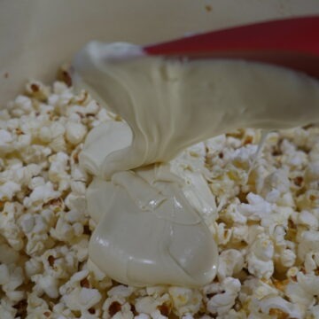 Pouring the melted white chocolate over the popcorn
